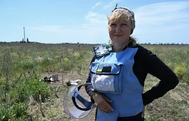 Tetiana Shpak, 51, a deminer with the HALO Trust NGO, poses for a photograph outside the village of Snigurivka, Mykolaiv province, on June 4 amid the Russian invasion of Ukraine. [Genya Savilov/AFP]