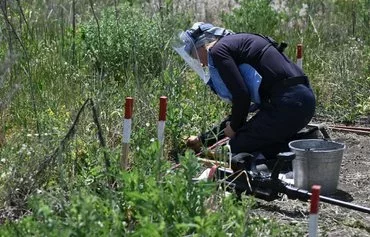 Shpak clears mines outside the village of Snigurivka, Mykolaiv province, on June 4 amid the Russian invasion of Ukraine. [Genya Savilov/AFP]