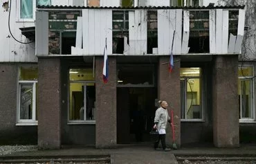 A woman cleans an area outside a hospital in Donetsk province, Russian-controlled Ukraine, on January 7, amid the Russian invasion of Ukraine. [AFP]