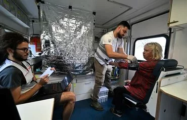 Volunteer medics examine local resident Valentyna, 62, in Staryi Karavan village, Donetsk province, last July 21 amid the Russian invasion of Ukraine. Many Ukrainian frontline villages have had no regular access to health care or other basic services for more than a year. [Genya Savilov/AFP]