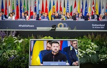 Ukrainian President Volodymyr Zelenskyy is seen on a screen during the Summit on Peace in Ukraine near Lucerne, Switzerland, on June 16. [Urs Flueeler/Pool/AFP]