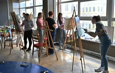 Women in Kyiv April 6 paint during an art therapy workshop organized by the charity Modern Ukraine for women who lost their husbands and sons in the war with Russia. [Sergei Supinsky/AFP]