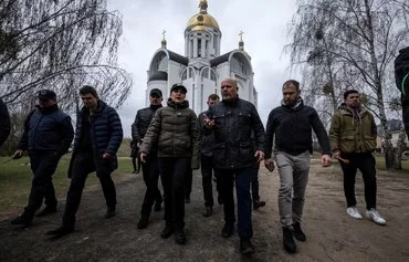 Ukrainian Prosecutor General Iryna Venediktova (C-L) and International Criminal Court Prosecutor Karim Khan (C-R) visit a mass grave on the grounds of the Church of Saint Andrew in Bucha, Ukraine, on the outskirts of Kyiv, on April 13, 2022, amid Russia's invasion of Ukraine.[Fadel Senna/AFP]