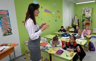 A teacher leads a lesson in Ukraine's first fully underground school, which was built to protect children from Russian missile attacks, in Kharkiv on May 13, amid the Russian invasion of Ukraine. [Sergey Bobok/AFP]