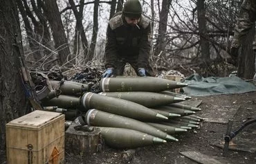 A Ukrainian serviceman prepares 155mm artillery shells near Bakhmut, eastern Ukraine, in 2023. [Aris Messinis/AFP]