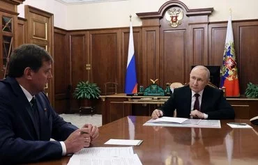 Russias President Vladimir Putin (right) attends a meeting with Leonid Pasechnik, the Moscow-appointed leader of Luhansk province, Ukraine, which is controlled by Russian forces, in Moscow, last August 23. [Mikhail Klimentyev/Pool/AFP]