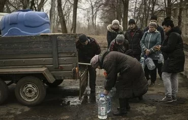 Residents of Chasiv Yar, Donbas province, Ukraine receive gallons of water on March 16, 2023, amid the Russian invasion of Ukraine. [Aris Messinis/AFP]