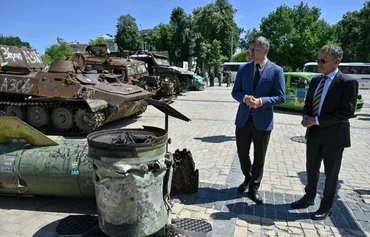 Ukrainian Foreign Minister Dmytro Kuleba (left) and Dutch Foreign Minister Caspar Veldkamp (right) walk past a display of destroyed Russian military vehicles in Kyiv July 6. [Genya Savilov/AFP]