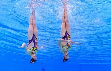 Ukraine's Maryna and Vladyslava Aleksiiva compete in the final of the women's duet free artistic swimming event during the 2024 World Aquatics Championships in Doha on February 8. [Manan Vatsyayana/AFP]