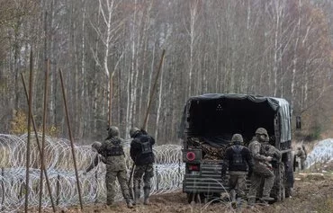 Польские солдаты возводят забор из армированной колючей ленты на границе с Россией. В ноябре 2022 года Польша приступила к строительству забора для предотвращения незаконных пересечений границы с российской стороны. Жердзины, северо-восточная Польша, 3 ноября 2022 г. [Войтек Радвански/AFP]