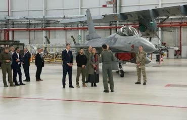 Belgian Prime Minister Alexander De Croo (C-L), Ukrainian President Volodymyr Zelenskyy and Belgian Defense Minister Ludivine Dedonder speak with a member of the military next to an F-16 fighter jet during an inspection visit on May 28. [Simon Wohlfahrt/AFP]