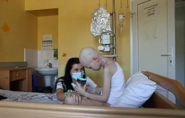 Darya Vertetska, 33, speaks to her daughter Kira, 8, at the children's ward of the National Cancer Institute in Kyiv, on July 12. Kira was injured by fragments of glass during a Russian missile attack on Okhmatdyt Children's Hospital on July 8 and was transferred to the National Cancer Institute with her mother. [Anatolii Stepanov/AFP]