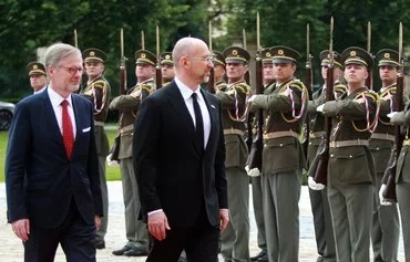 Czech Prime Minister Petr Fiala (left) and Ukrainian Prime Minister Denys Shmyhal review a military honor guard during a welcome ceremony prior to a meeting of the Czech and Ukrainian cabinets in Prague on July 16. [Milan Kammermayer/AFP]