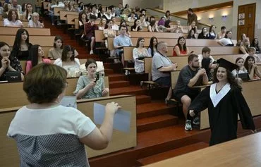 A graduate of Kyiv National Linguistic University receives her diploma in Kyiv on June 28. [Genya Savilov/AFP]