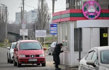 A woman coming from breakaway Transnistria presents her documents to border officers of that region at the Varnita crossing point March 1. Pro-Russian officials in the breakaway region February 28 appealed to Russia for 'protection,' amid fears Transnistria could become a new flashpoint in the Russo-Ukrainian war. [Daniel Mihailescu/AFP]