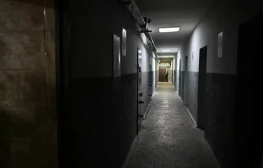 A Ukrainian officer walks past cells where Russian prisoners of war are detained at an undisclosed location in Sumy province on August 19. [Genya Savilov/AFP]