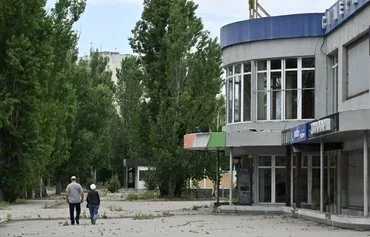 Pedestrians walk along a street in Korabel district, Kherson province, Ukraine, on June 2 amid the Russian invasion of Ukraine. [Genya Savilov/AFP]