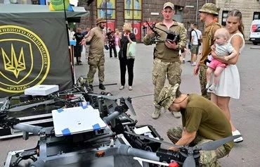 Ukrainian servicemen present drones at a recruiting point in Kyiv on July 4. [Sergei Supinsky/AFP]