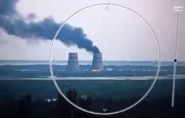 A screenshot from a video posted by Ukrainian President Volodymyr Zelenskyy August 11 on X shows black smoke rising from a cooling tower of the Russian-held ZNPP.