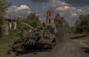 Ukrainian servicemen operate an armoured military vehicle on a road near the border with Russia, in Sumy province, Ukraine, on August 14. [Roman Pilipey/AFP]