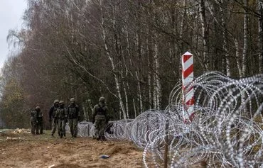 Polish soldiers build a concertina fence on the Polish-Russian border in Zerdziny, Poland, on November 3, 2022. [Wojtek Radwanski/AFP]