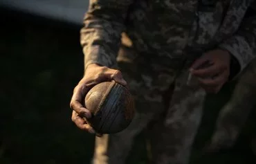 A soldier from a Ukrainian mobile anti-aircraft brigade holds an unexploded Russian cluster bomb in Khmelnytsky province on July 8. [Florent Vergnes/AFP]