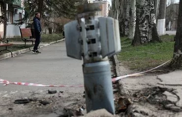 A man walks past an unexploded tail section of a 300mm rocket that appeared to contain cluster bombs. The rocket was embedded in the ground after shelling in Lysychansk, Luhansk province, Ukraine, April 11, 2022. [Anatolii Stepanov/AFP]