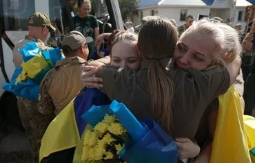 Olena Tolkacheva (2R), director of the Azov brigade patronage service, embraces servicewomen of the Azov brigade after their release from Russian captivity at an undisclosed location near the Ukrainian-Belarusian border on September 13. [Anatolii Stepanov/AFP]