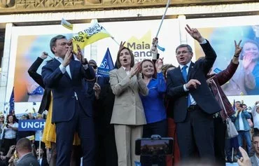 Moldovan President Maia Sandu (center) applauds onstage during a rally to launch her reelection campaign in Chisinau, on September 20. [Elena Covalenco/AFP]