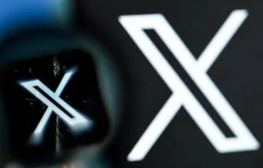 The logo of X on a smartphone screen. [Kirill Kudryavtsev/AFP]