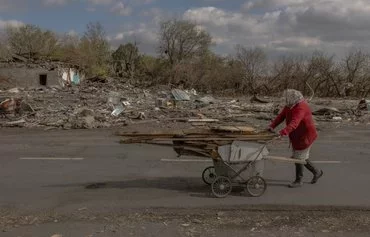 Пожилая женщина собирает валежник в районе, который недавно подвергся обстрелам. Ясеновое, Донецкая область, 8 октября. [Роман Пилипей/AFP]