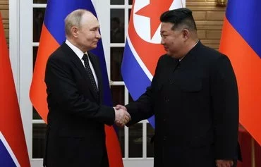 In this pool photograph distributed by the Russian state agency Sputnik, North Korea's leader Kim Jong Un (right) and and Russian President Vladimir Putin shake hands after a welcoming ceremony at Kim Il Sung Square in Pyongyang on June 19. The visit laid the groundwork to boost defence ties between the two nuclear-armed countries as Moscow pursues its war in Ukraine. [Gavriil Grigorov/POOL/AFP]