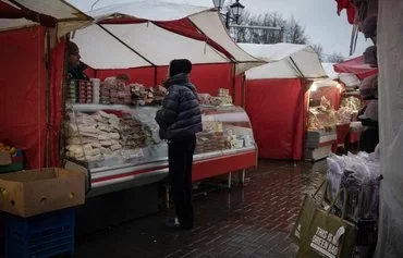 Женщина покупает продукты на уличном рынке. Московская область, 21 ноября. [Наталья Колесникова/AFP]