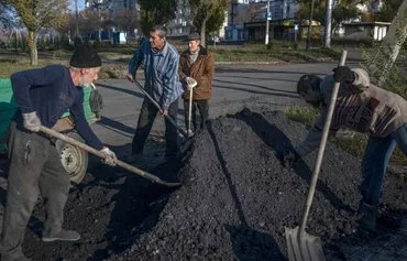 Ukrainians load a small truck with coal to distribute among the public for winter preparations, outside Bakhmut on November 9, 2022, amid the Russian invasion of Ukraine. [Bulent Kilic/AFP]