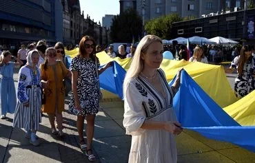 Представители украинской диаспоры разворачивают 100-метровый украинский флаг в честь Дня независимости Украины. Катовице (Польша), 24 августа. [Сергей Гапон/AFP]