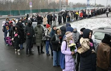 Скорбящие с цветами в очереди, чтобы почтить память покойного лидера российской оппозиции Алексея Навального у его могилы. Москва, 16 февраля. [Александр Неменов/AFP]