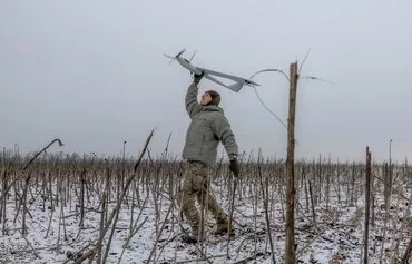 A member of an Azov Brigade drone team with the callsign Sava launches a surveillance drone towards Russian positions in Toretsk, Donetsk province, February 4. [Roman Pilipey/AFP]